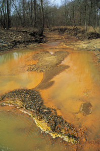 Iron hydroxide precipitate stains a stream receiving acid drainage from a mine